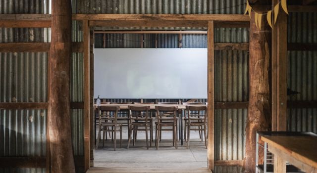Looking into a room with wooden chairs and dining table